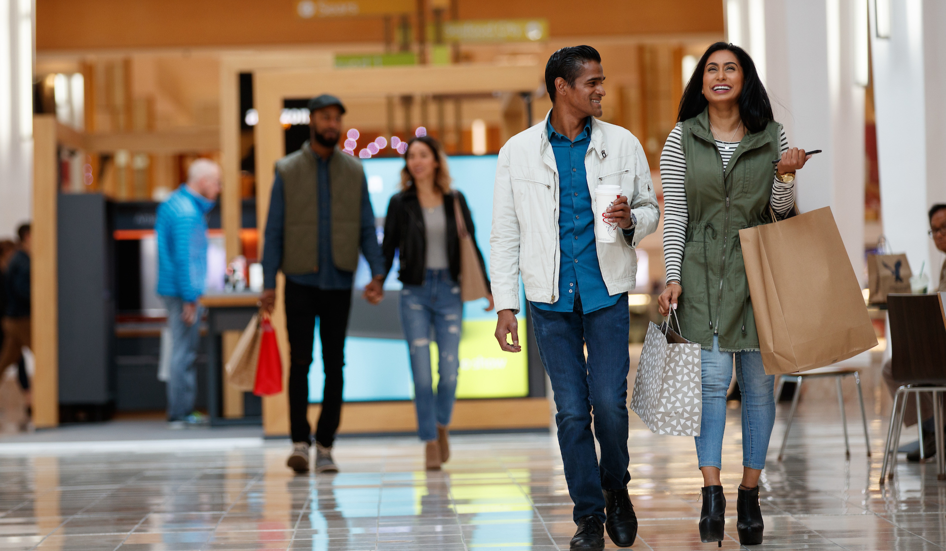 a few people walking in a mall